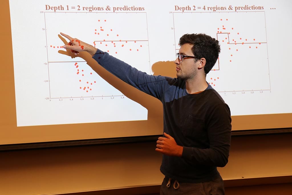 Student pointing at a projection screen to discuss data