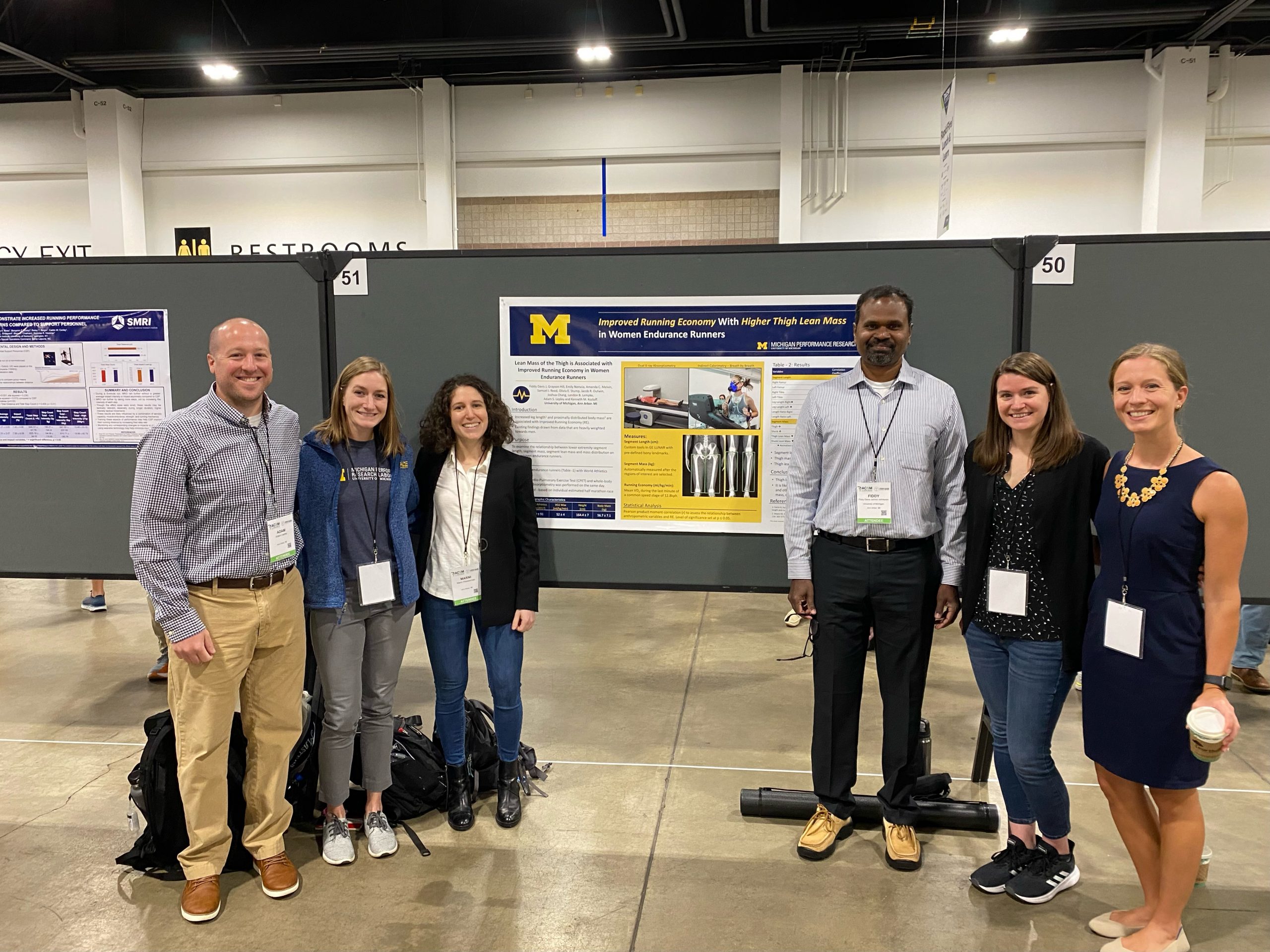 Group of scholars standing around presentation display